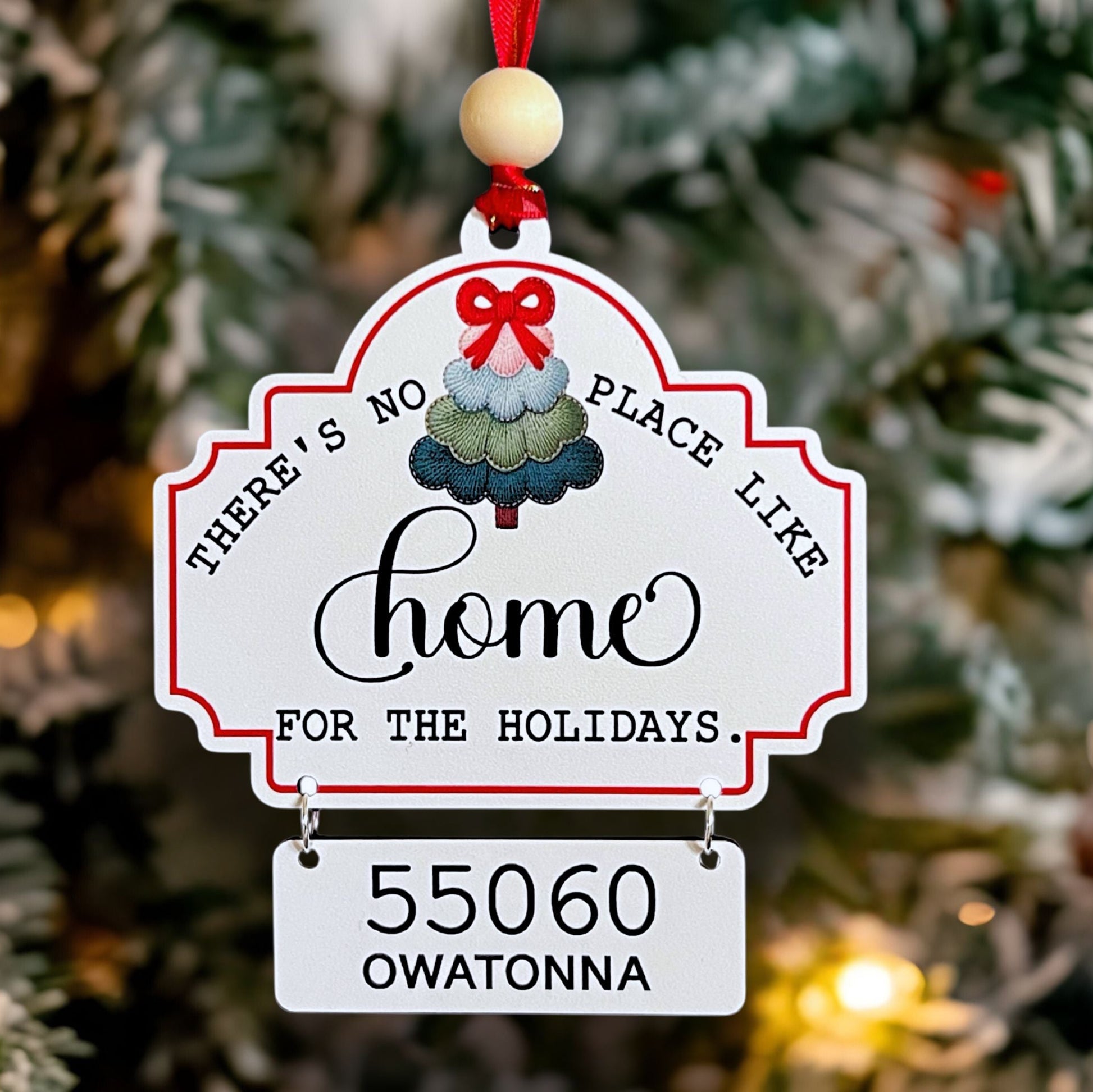Decorative Christmas Zip Code ornament with zip code, city and colorful tree design on a Christmas tree.