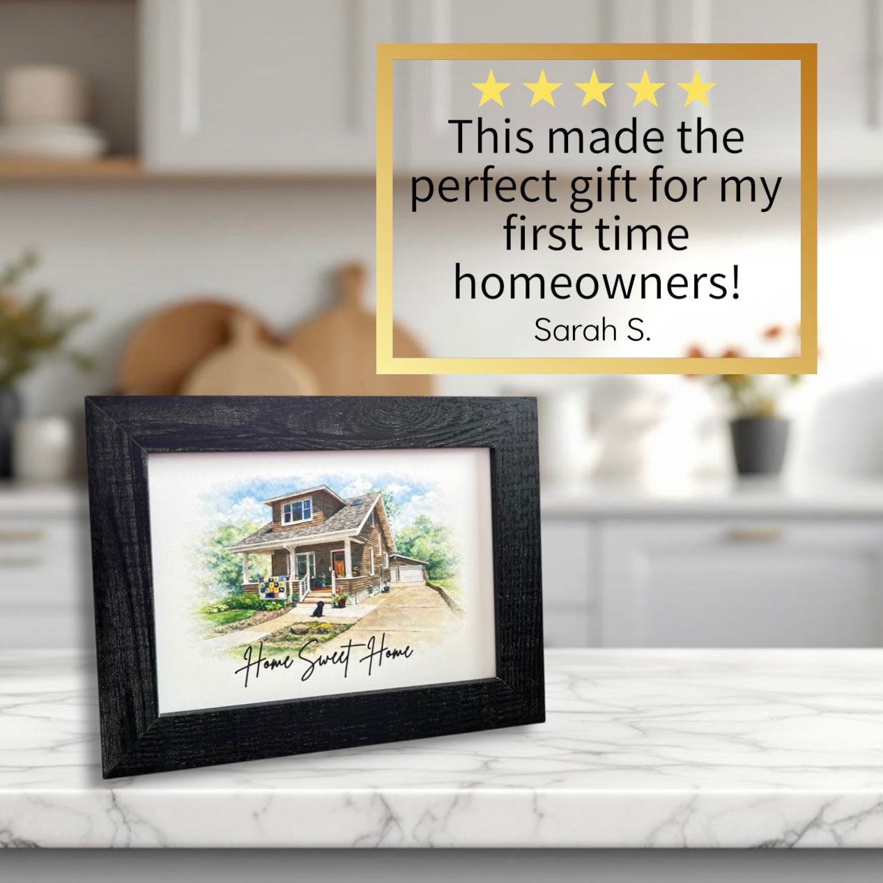 Framed artwork of a house with a five-star rating and review on a kitchen counter.