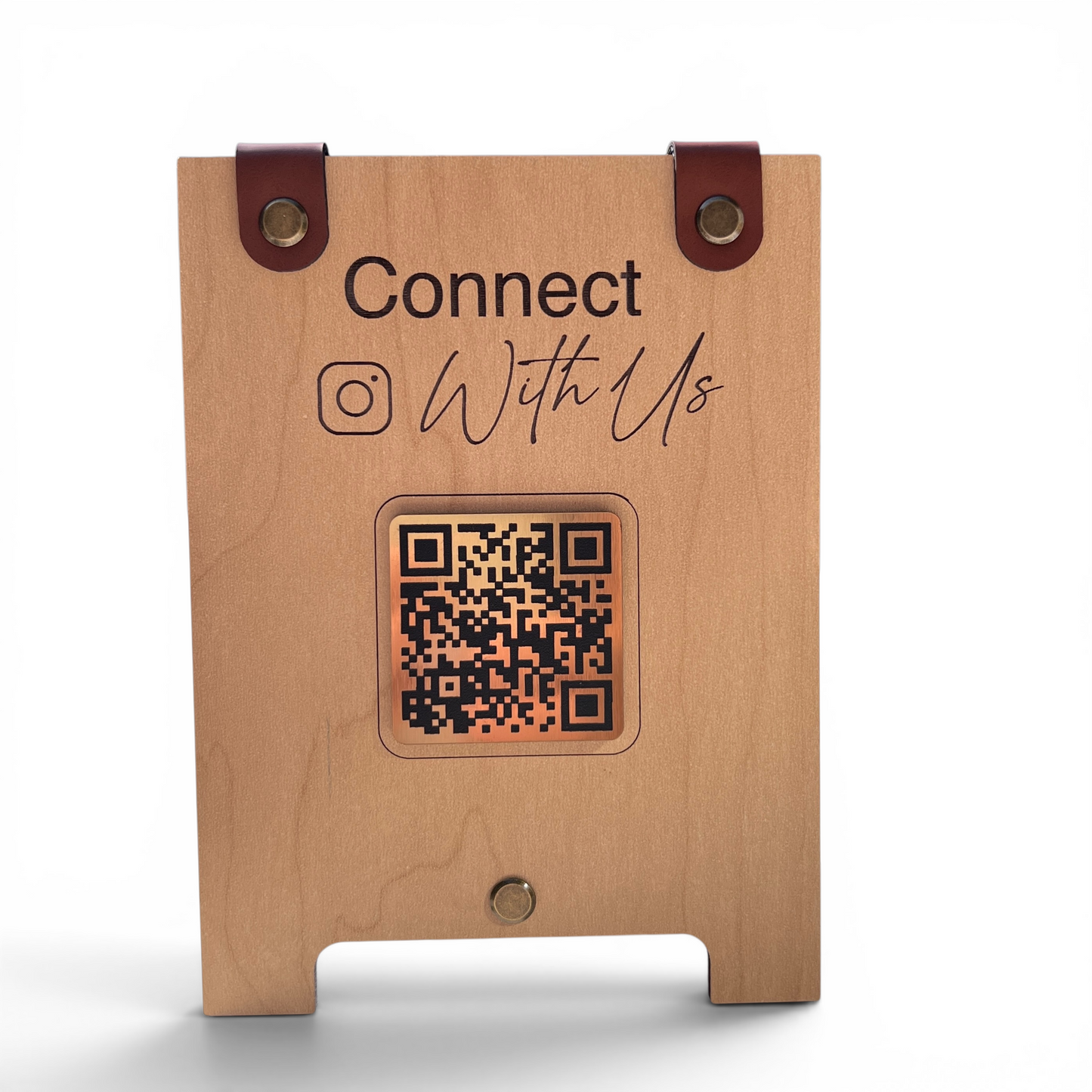 A personalized wooden stand with a natural light wood grain finish, featuring dark brown leather strap accents at the top, laser-engraved text reading 'Connect With Us' and an Instagram logo-with a gold QR code in the center, shown on a white background.