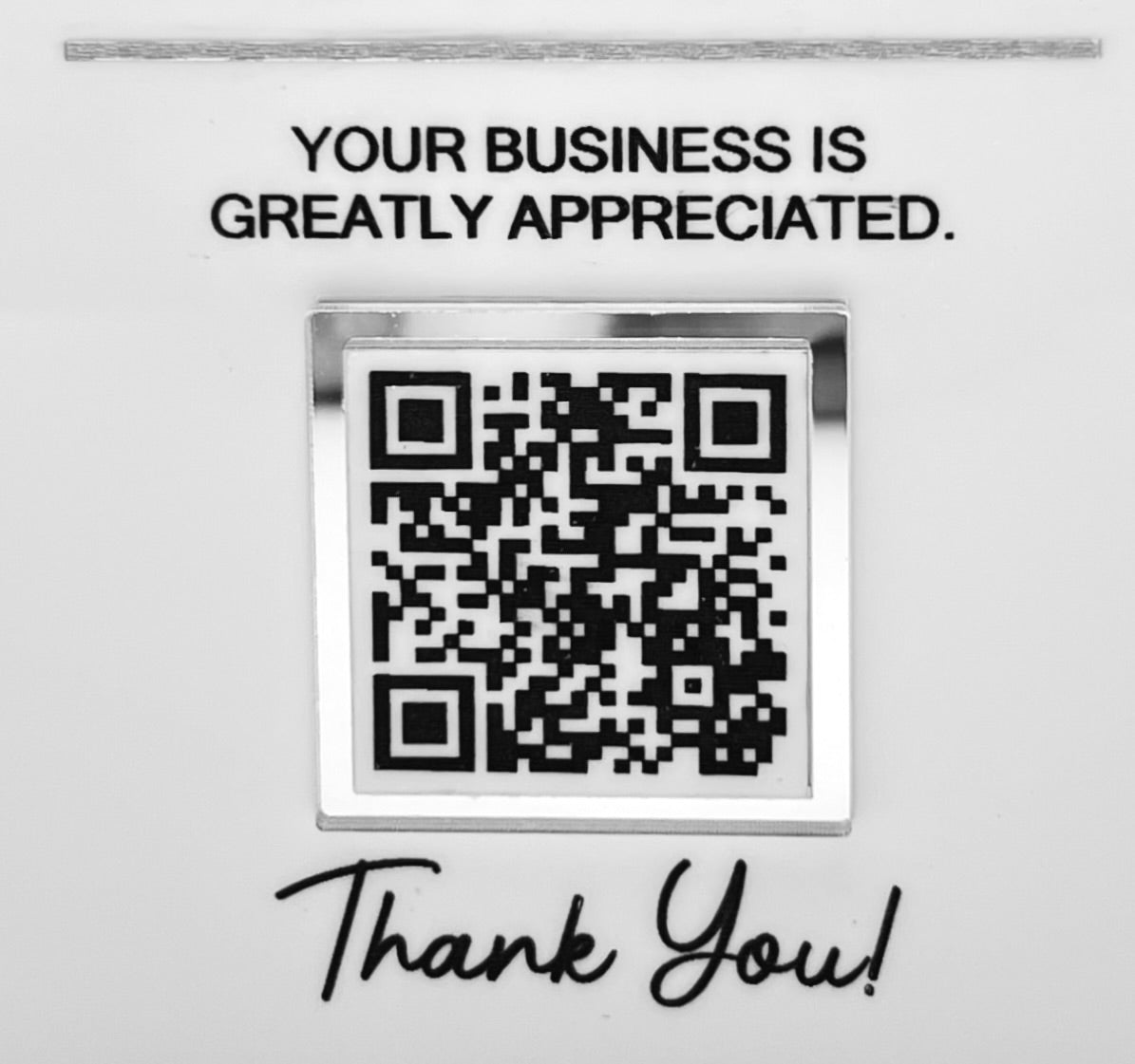 A square black and white QR code  surrounded by silver mirror border centered on a white background, with the text 'YOUR BUSINESS IS GREATLY APPRECIATED.' above it and 'Thank You!' in script below.