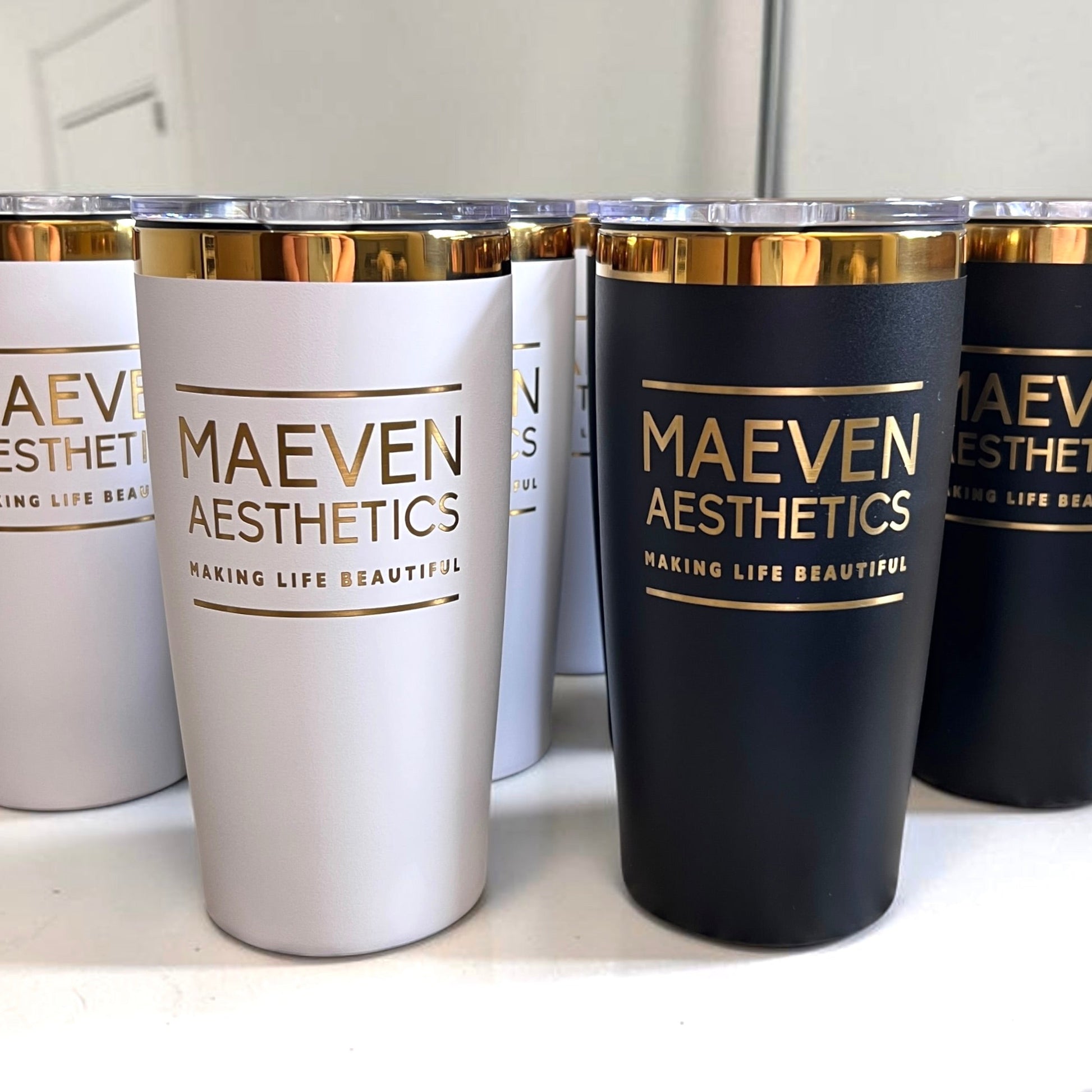Set of tumblers with 'MAEVEN AESTHETICS' branding on a white surface.