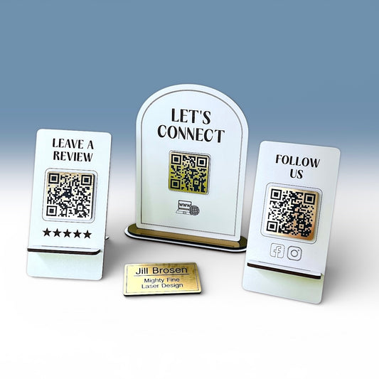 Three white signs with QR codes and text on a gray background